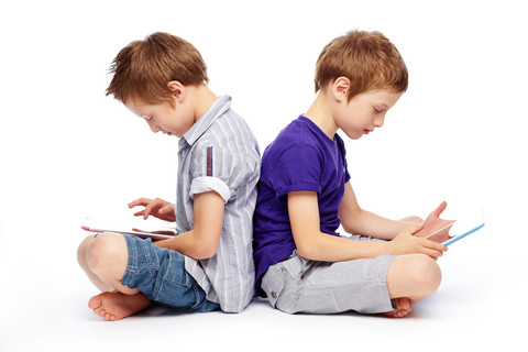 to-drenge-sidder-med-ryggen-til-hinanden-med-tablets